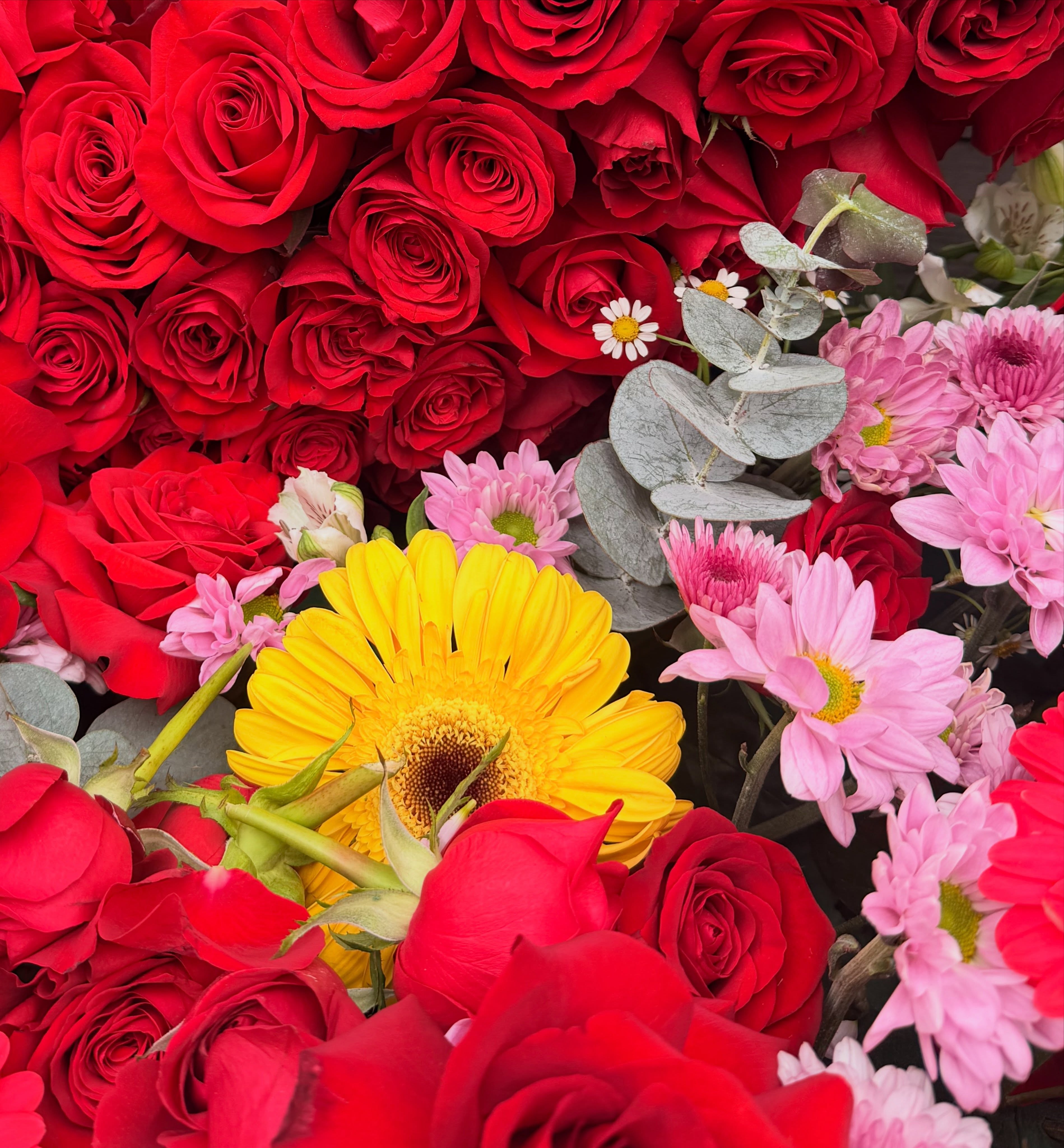 Detalle de rosas rojas, gerberas y flores rosas